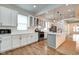Updated eat-in kitchen featuring white cabinets, quartz counters, stainless appliances, and hardwood floors at 1229 N Keystone Ave, Indianapolis, IN 46201