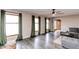 Bright living room featuring large windows with curtains, hardwood floors, and a gray sectional sofa at 10909 Wonderland Dr, Indianapolis, IN 46239