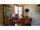 Cozy home office featuring a wooden desk, decorative display cabinet, and window with natural light at 4695 Shireton Ct, Indianapolis, IN 46254