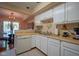 Bright kitchen with white cabinetry and tile flooring adjacent to a dining area at 4695 Shireton Ct, Indianapolis, IN 46254