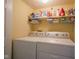 A laundry room featuring side-by-side washer and dryer with overhead shelving at 4695 Shireton Ct, Indianapolis, IN 46254
