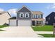 Beautiful two-story home with a three-car garage, well-manicured lawn, and a charming front porch at 1130 Cobra Dr, Franklin, IN 46131