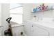 Well-lit laundry room with a window, white washer and dryer, and shelving for storage at 1130 Cobra Dr, Franklin, IN 46131
