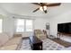 Cozy living room with a ceiling fan, plush seating, a patterned rug, and large windows at 1130 Cobra Dr, Franklin, IN 46131