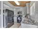 Modern kitchen with gray cabinets, granite countertops, and black appliances at 7438 Haw Dr, Nineveh, IN 46164