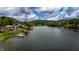 Panoramic aerial view of lakeside homes with private docks surrounded by lush green trees on a partly cloudy day at 4161 S Summit Ln, Columbus, IN 47201