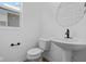 Bathroom features a stylish round mirror and a modern pedestal sink at 5143 Rolling Meadow Blvd, Indianapolis, IN 46237