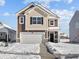 Charming two-story home featuring a two-car garage, classic brown siding, and a snow-covered front yard at 5143 Rolling Meadow Blvd, Indianapolis, IN 46237