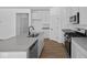 Modern kitchen featuring stainless steel appliances, a large island with a sink, and sleek white cabinets at 5143 Rolling Meadow Blvd, Indianapolis, IN 46237