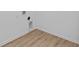 View of laundry room hookups with wood floors and white trim at 5143 Rolling Meadow Blvd, Indianapolis, IN 46237