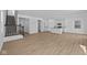 Open floor plan featuring light wood-look floors, a staircase, and a stylish modern kitchen with an island at 5143 Rolling Meadow Blvd, Indianapolis, IN 46237
