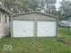 View of detached 2-car garage with white doors and neutral metal siding at 237 Ringwood Way, Anderson, IN 46013