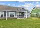 Backyard of home with covered patio, neutral vinyl siding, white fence, and lush green grass at 3544 Wrangler Dr, Bargersville, IN 46106