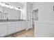 Bright bathroom showcasing a double sink vanity, gray countertops, and doorway leading to the walk-in closet at 3544 Wrangler Dr, Bargersville, IN 46106