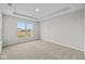 A light-filled bedroom with a tray ceiling, carpet, and a view of the neighborhood through a large window at 3544 Wrangler Dr, Bargersville, IN 46106