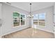 Bright dining area featuring modern chandelier, wood-look floors, and expansive windows with scenic views at 3544 Wrangler Dr, Bargersville, IN 46106