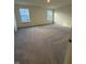 Bright bedroom with plush carpet and two sunny windows overlooking the neighborhood at 11015 Walter Dr, Indianapolis, IN 46235