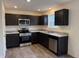 Modern kitchen equipped with stainless steel appliances, granite countertops, and dark brown cabinets at 11015 Walter Dr, Indianapolis, IN 46235