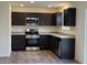 Modern kitchen equipped with stainless steel appliances, granite countertops, and dark brown cabinets at 11015 Walter Dr, Indianapolis, IN 46235