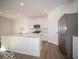 Bright kitchen with white cabinets, stainless steel fridge, and a large center island at 146 Velvet Hat Rd, Danville, IN 46122