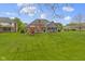 Expansive back yard with lush green grass, deck, and playground at 603 Ophelia Dr, Avon, IN 46123
