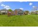 Expansive back yard with lush green grass, deck, and playground at 603 Ophelia Dr, Avon, IN 46123