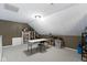 Versatile bonus room with neutral carpet, storage shelves, and a white table and chair at 603 Ophelia Dr, Avon, IN 46123