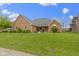 All-brick one-story house featuring a well-manicured front lawn, lovely landscaping and rocking chairs on the front porch at 603 Ophelia Dr, Avon, IN 46123