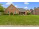 Charming brick home with well-maintained landscaping and a cozy front porch under a cloudy sky at 603 Ophelia Dr, Avon, IN 46123