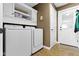 Well-equipped laundry room with modern machines, overhead cabinets, and a convenient exterior door at 603 Ophelia Dr, Avon, IN 46123