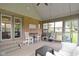 Enclosed porch with brick accent wall, large windows, hanging swing, and comfortable outdoor seating at 603 Ophelia Dr, Avon, IN 46123