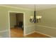 Traditional dining room with wainscoting, hardwood floors, and chandelier, adjacent to the brick fireplace at 6205 Bramshaw Rd, Indianapolis, IN 46220