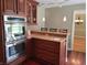 Stylish kitchen with dark wood cabinets, stainless steel double ovens and a breakfast bar area at 6205 Bramshaw Rd, Indianapolis, IN 46220