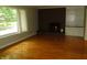 Comfortable living room boasts a brick fireplace, hardwood floors and large window with natural light at 6205 Bramshaw Rd, Indianapolis, IN 46220