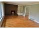 Sunlit living room with a brick fireplace, hardwood floors and a view into the dining room at 6205 Bramshaw Rd, Indianapolis, IN 46220
