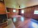 Open living room with hardwood floors, fireplace, ceiling fan, and natural light from the windows at 6205 Bramshaw Rd, Indianapolis, IN 46220