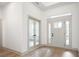 Bright entryway with light hardwood floors, neutral walls, and French doors at 15786 Vitalize Run, Fishers, IN 46040