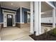 Inviting front porch with a dark blue exterior and brick base at 15786 Vitalize Run, Fishers, IN 46040