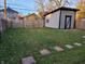 Backyard featuring a fenced yard with a storage shed, complemented by stepping stones on a green lawn at 2828 Robson St, Indianapolis, IN 46201