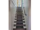 Basement staircase with a dark metal handrail and updated gray and white wood treads at 2828 Robson St, Indianapolis, IN 46201