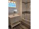 Renovated bathroom featuring a vanity, new lighting fixtures, and a tiled shower and bath at 2828 Robson St, Indianapolis, IN 46201