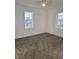 Well-lit bedroom with neutral carpet flooring and two windows with exterior views at 2828 Robson St, Indianapolis, IN 46201
