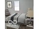 Cozy bedroom featuring a comfortable bed, chair, and window with natural light, and decorative art at 2828 Robson St, Indianapolis, IN 46201