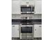 Modern kitchen appliances including a stainless steel oven and microwave surrounded by white cabinets and a sleek backsplash at 2828 Robson St, Indianapolis, IN 46201