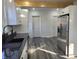 Spacious kitchen featuring white cabinets, stainless steel appliances, granite counters, and modern gray flooring at 2828 Robson St, Indianapolis, IN 46201