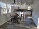 Eat-in kitchen area with a round wood table, modern chandelier, and a view into the kitchen with white cabinets and stainless appliances at 2828 Robson St, Indianapolis, IN 46201