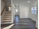 Bright living room featuring sleek gray floors, white walls, and a staircase with wood accents leading to the second floor at 2828 Robson St, Indianapolis, IN 46201