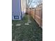 Side yard featuring stepping stones along a wooden fence, with a view of gray siding and a small window at 2828 Robson St, Indianapolis, IN 46201