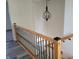 Staircase with wood handrail, black metal spindles, and gray flooring at 2828 Robson St, Indianapolis, IN 46201