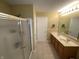Bathroom featuring double sinks, a shower with a glass door and neutral colored tile flooring at 5211 Nicodemus Dr, Plainfield, IN 46168